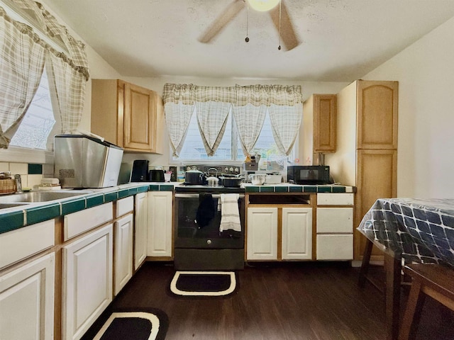 kitchen with range with electric cooktop, light brown cabinetry, dark hardwood / wood-style flooring, tile counters, and ceiling fan