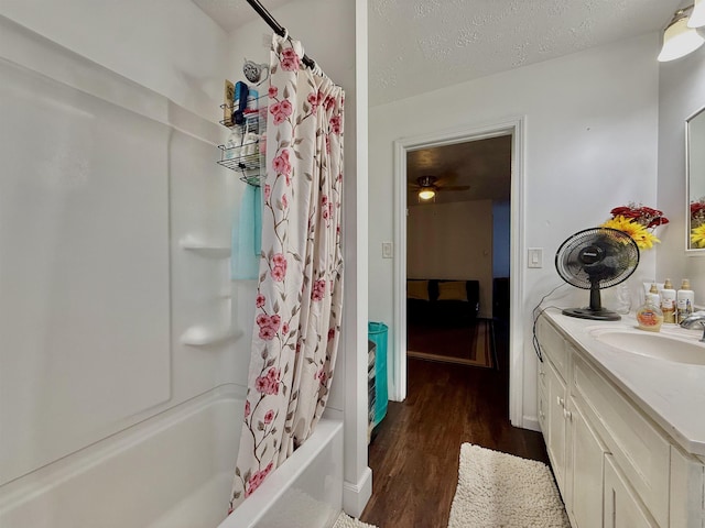 bathroom featuring vanity, hardwood / wood-style floors, shower / tub combo, and a textured ceiling