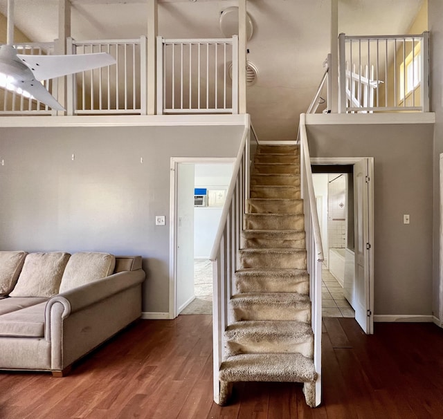 staircase featuring a high ceiling and wood-type flooring