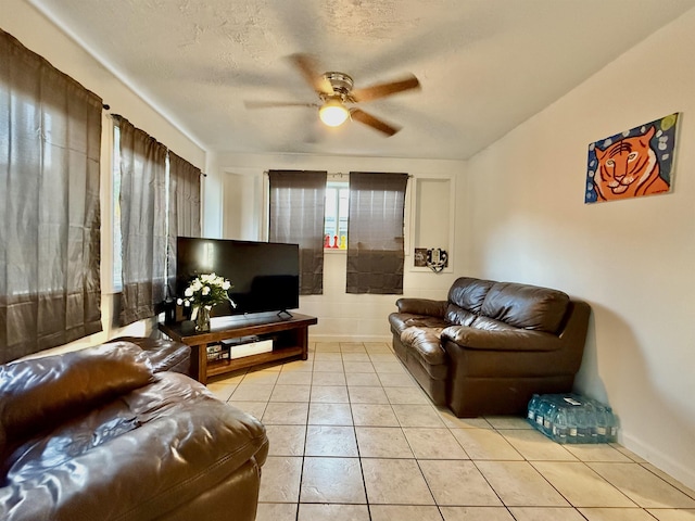 living room featuring light tile patterned floors, a textured ceiling, and ceiling fan