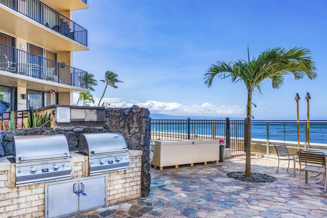 view of patio / terrace with grilling area, area for grilling, a water view, and a balcony