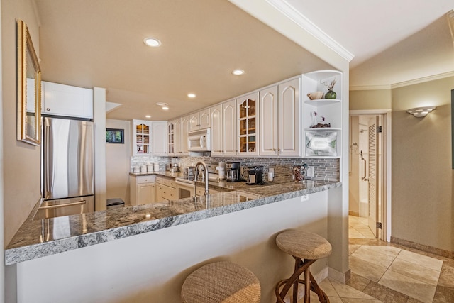 4401 Lower Honoapiilani Rd Unit A-103, Lahaina, HI 96761 - kitchen with freestanding refrigerator, white microwave, open shelves, ornamental molding, and tasteful backsplash