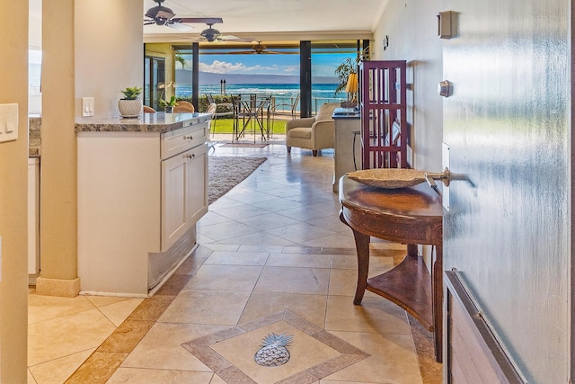 corridor featuring a water view and light tile patterned floors