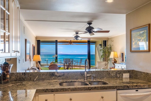 kitchen featuring dishwasher, a water view, sink, and white cabinets