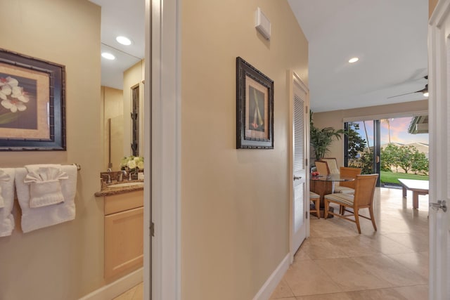 corridor with recessed lighting, baseboards, and light tile patterned floors