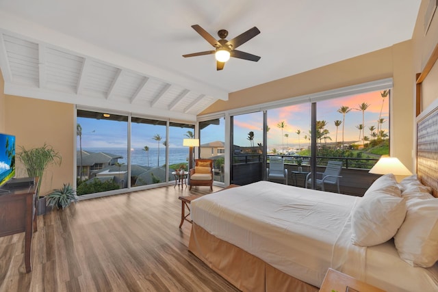 bedroom with lofted ceiling with beams, a sunroom, ceiling fan, wood finished floors, and access to outside