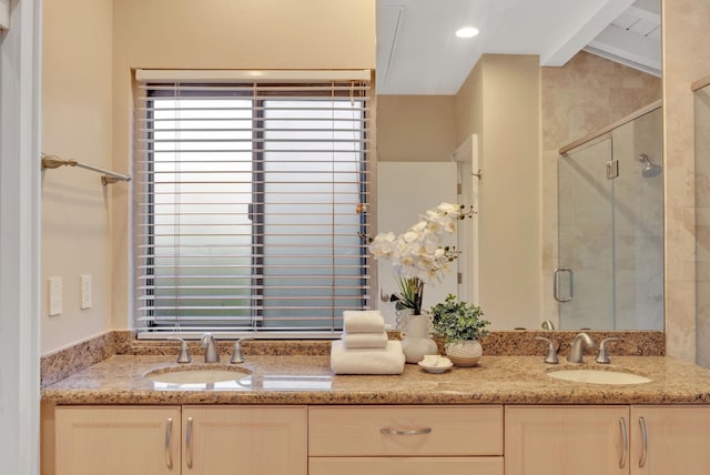 full bathroom with a stall shower, a sink, lofted ceiling with beams, and double vanity