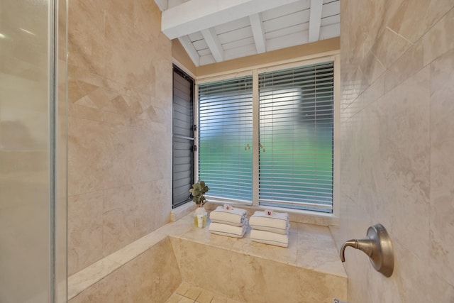 full bathroom with lofted ceiling with beams, a shower, and tile walls