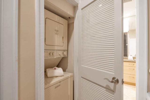 laundry area with stacked washer and dryer, laundry area, and visible vents