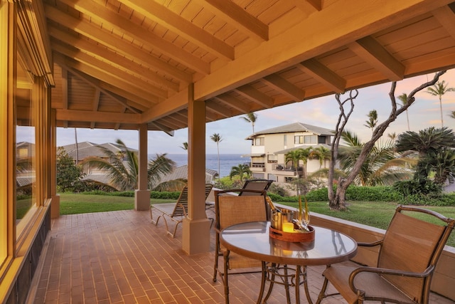 wooden terrace with a lawn and a patio area