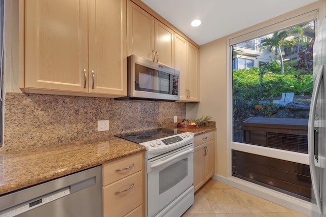 kitchen featuring light tile patterned floors, decorative backsplash, light stone countertops, stainless steel appliances, and recessed lighting