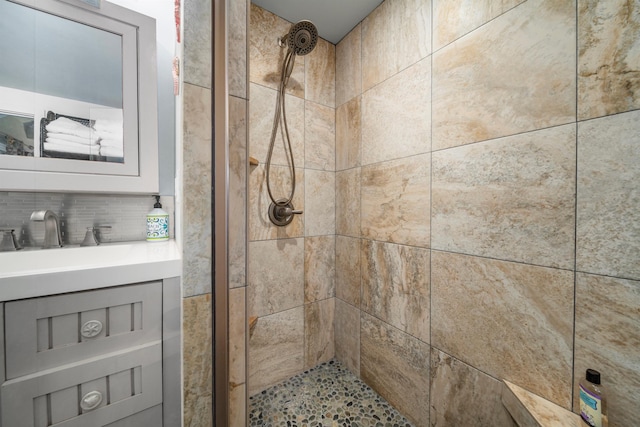 bathroom featuring a tile shower and sink