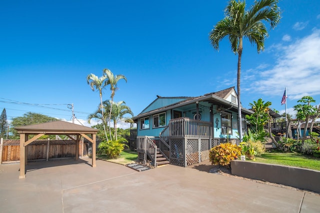 view of side of home featuring covered porch and a gazebo