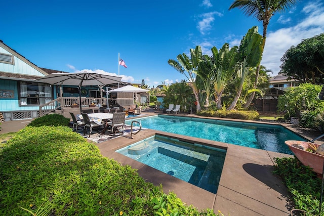 view of swimming pool featuring a patio area and an in ground hot tub