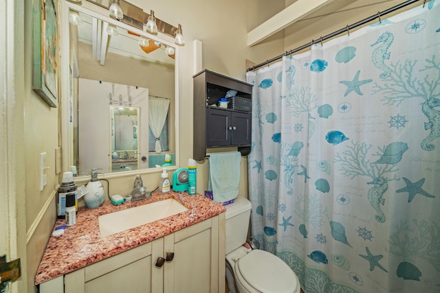 bathroom featuring curtained shower, vanity, and toilet