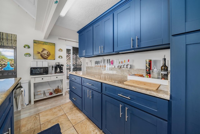 kitchen featuring light tile patterned floors, blue cabinetry, a textured ceiling, beam ceiling, and light stone counters