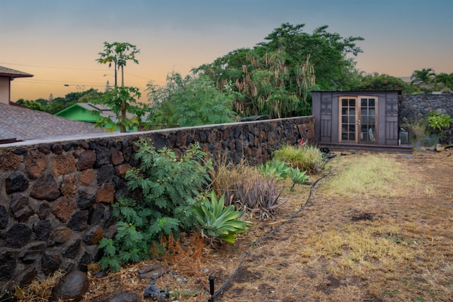 yard at dusk featuring an outdoor structure