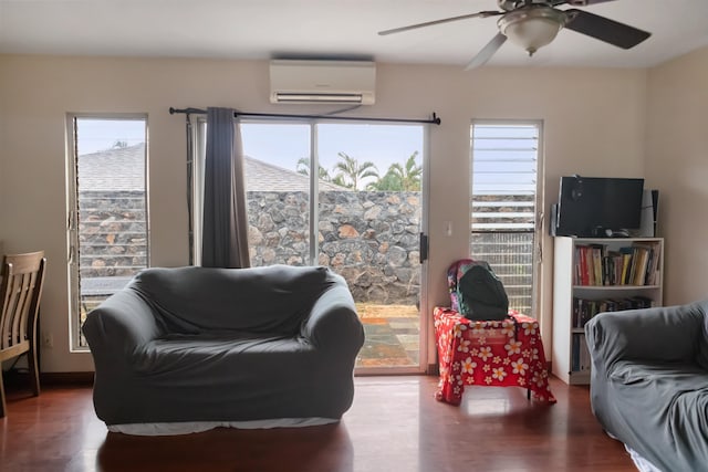 living room featuring ceiling fan, wood-type flooring, and a wall unit AC