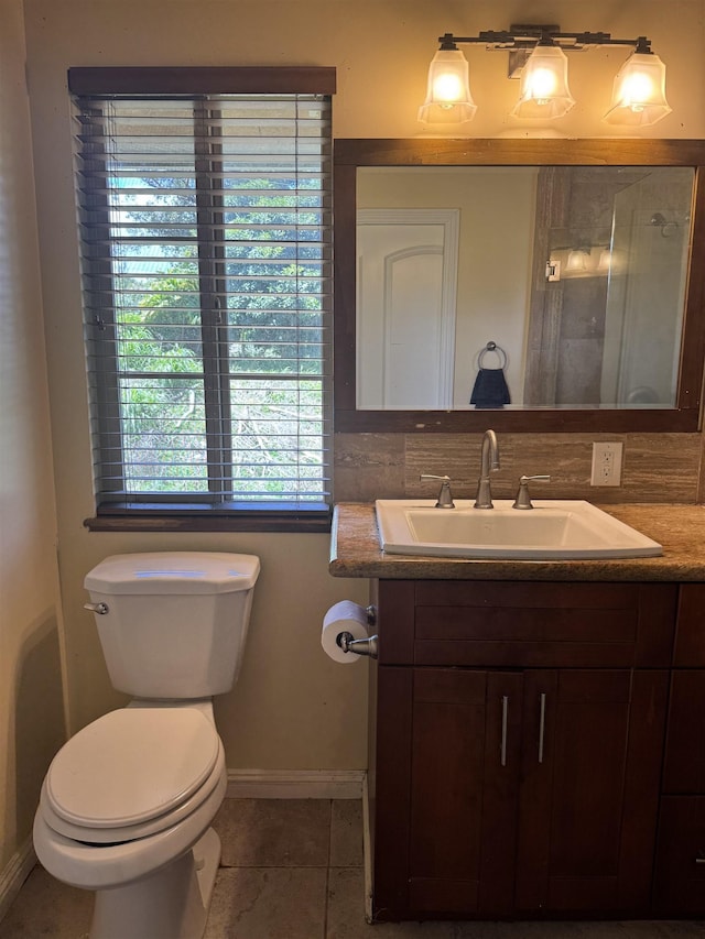 bathroom featuring baseboards, tile patterned floors, toilet, and vanity