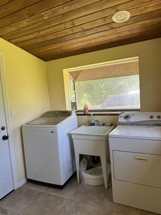 clothes washing area with laundry area, light tile patterned floors, wooden ceiling, and washing machine and clothes dryer