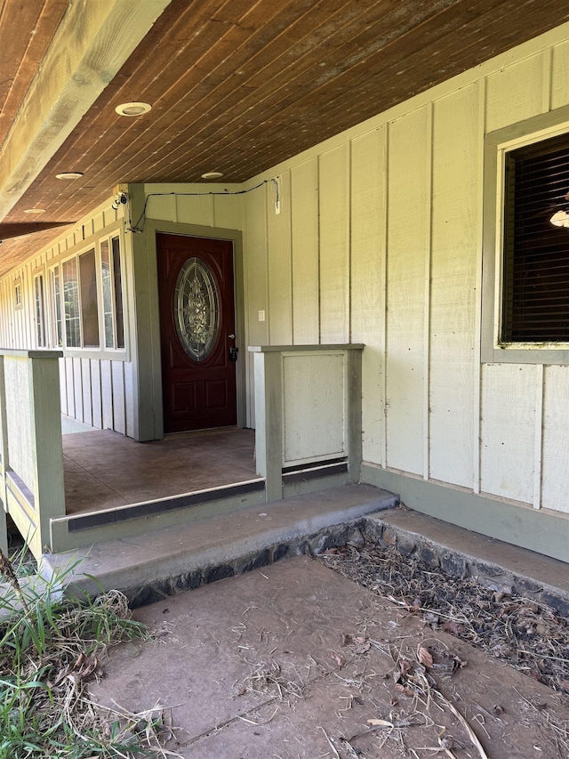 entrance to property featuring board and batten siding and covered porch