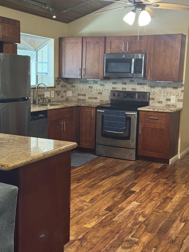 kitchen featuring ceiling fan, dark wood-type flooring, a sink, appliances with stainless steel finishes, and backsplash