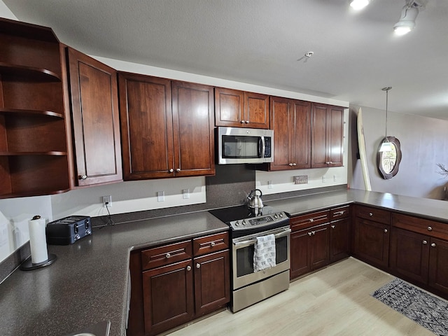 kitchen with light hardwood / wood-style flooring, pendant lighting, and appliances with stainless steel finishes