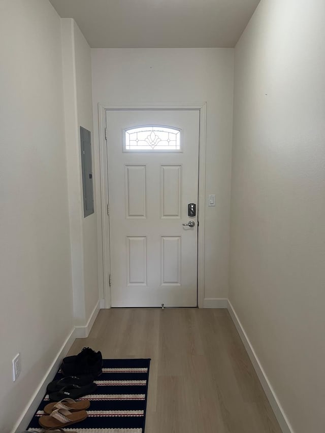 doorway with electric panel and light hardwood / wood-style flooring