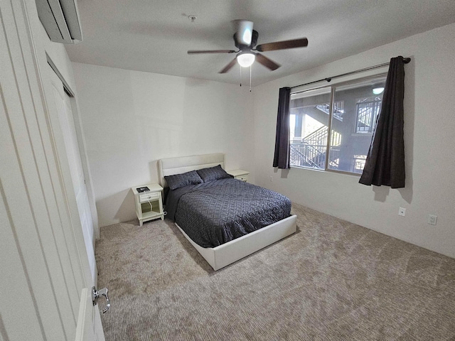 carpeted bedroom with a wall mounted AC and ceiling fan