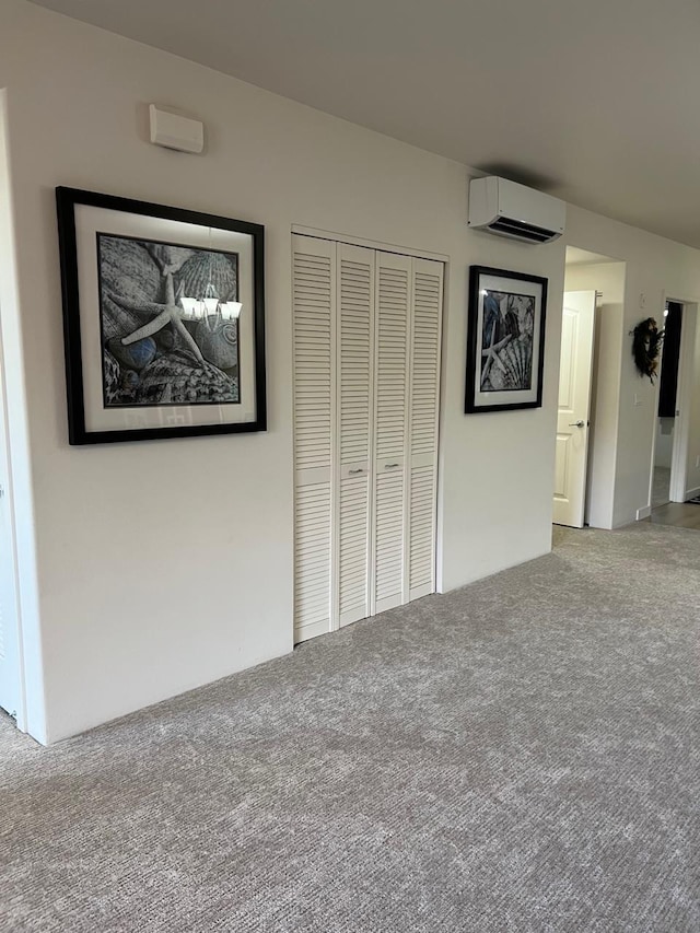 unfurnished bedroom with carpet, an AC wall unit, and a closet