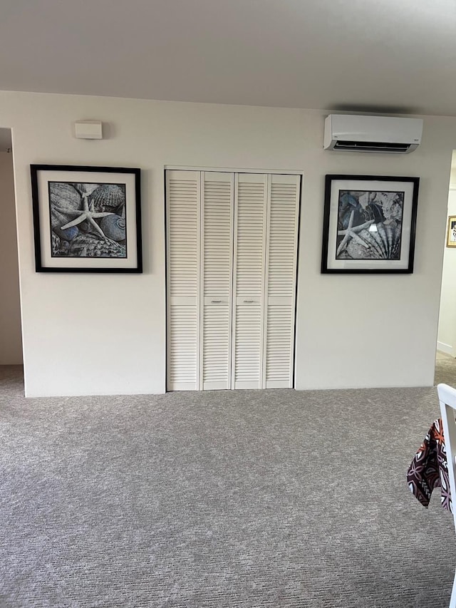 unfurnished bedroom featuring a closet, carpet, and a wall mounted air conditioner