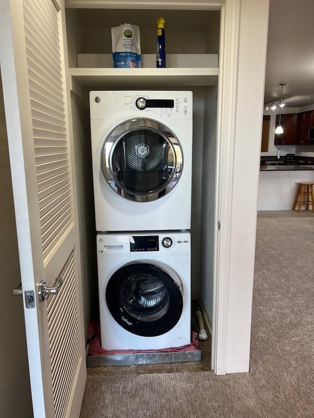 washroom featuring carpet flooring and stacked washer / dryer