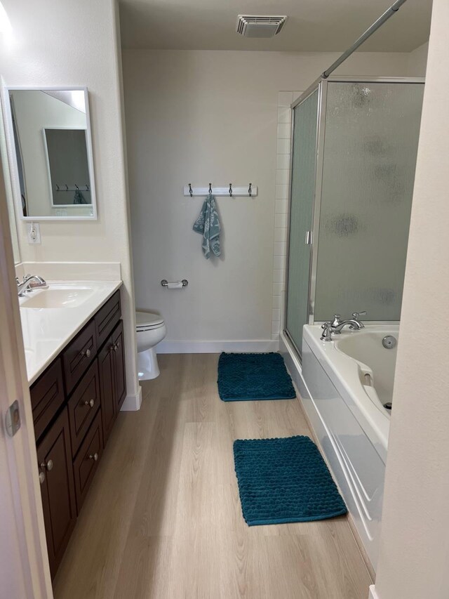 full bathroom featuring wood-type flooring, vanity, toilet, and independent shower and bath