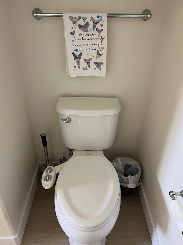 bathroom with hardwood / wood-style flooring and toilet