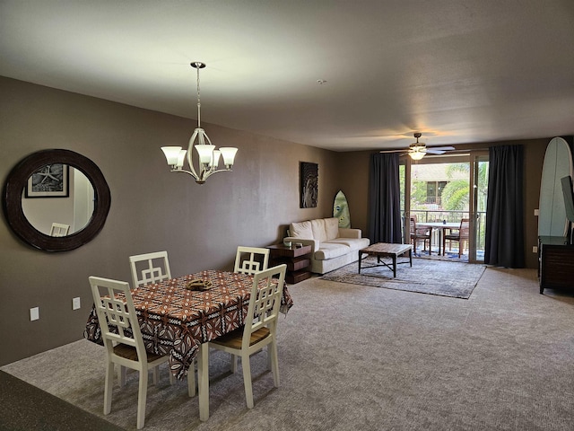 dining room featuring carpet flooring and ceiling fan with notable chandelier