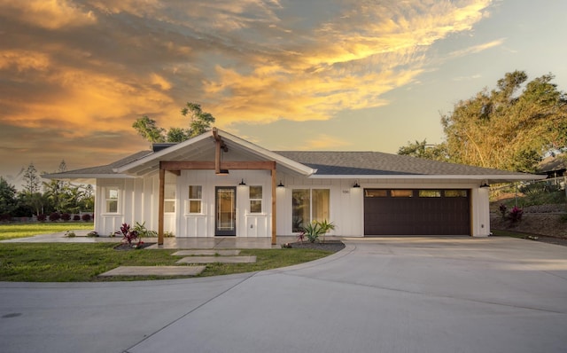 view of front of home featuring board and batten siding, concrete driveway, a shingled roof, and an attached garage