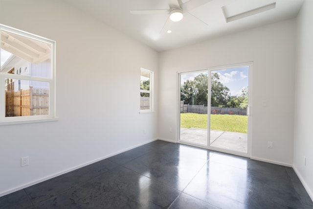 unfurnished room with finished concrete flooring, baseboards, and a ceiling fan