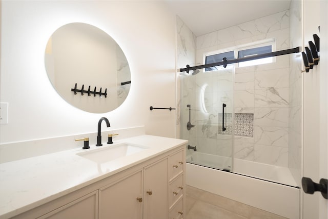 bathroom featuring combined bath / shower with glass door and vanity