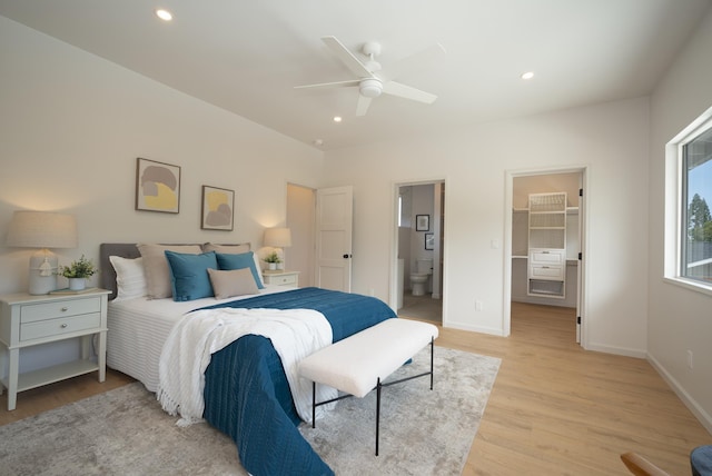 bedroom featuring light wood-style flooring, recessed lighting, baseboards, a spacious closet, and ensuite bath