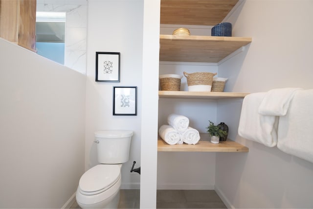 bathroom featuring tile patterned floors, toilet, and baseboards