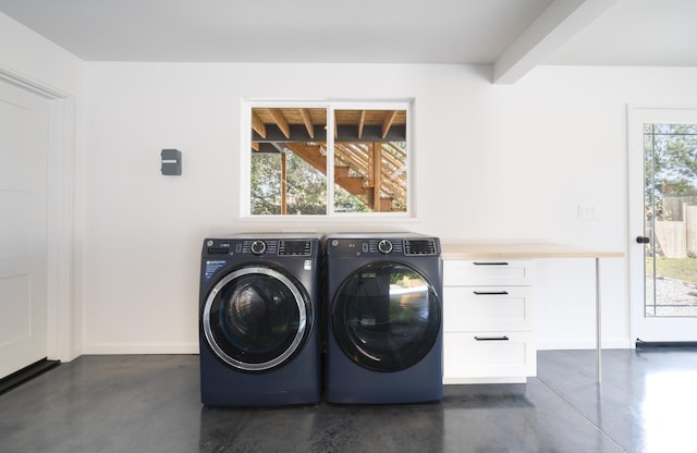 clothes washing area with washing machine and dryer, cabinet space, and baseboards