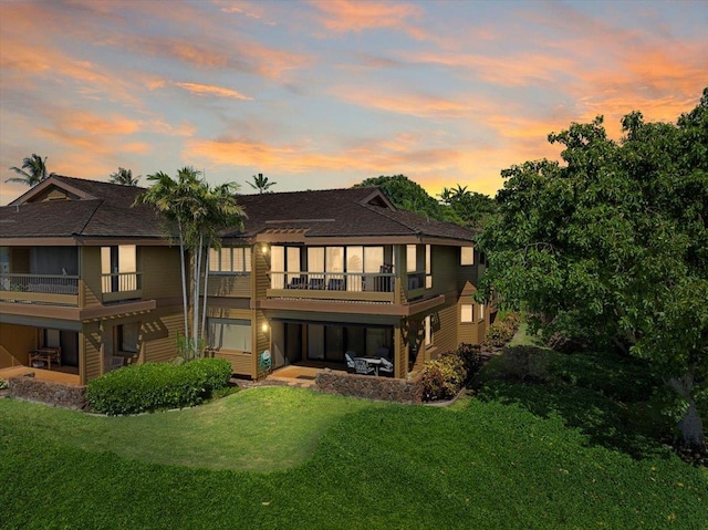 back of house featuring a balcony, a yard, a patio area, and a pergola