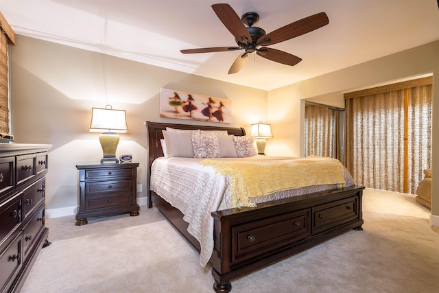 bedroom featuring ceiling fan, baseboards, and light colored carpet