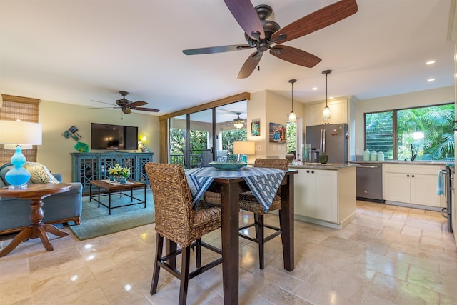 dining space with recessed lighting, stone tile flooring, and plenty of natural light
