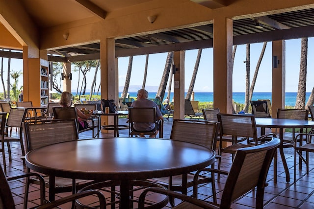 dining room with a water view, plenty of natural light, and tile patterned floors