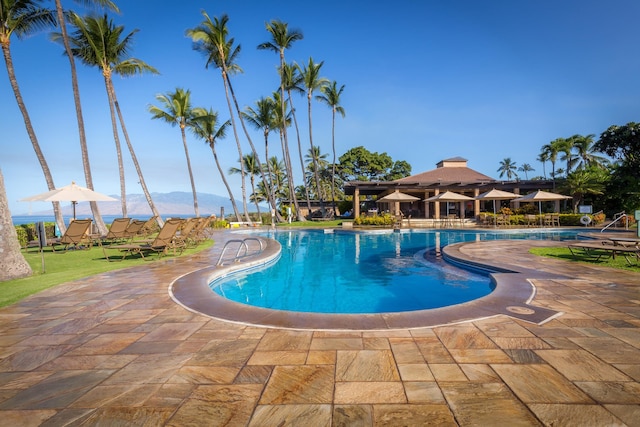 community pool with a mountain view and a patio