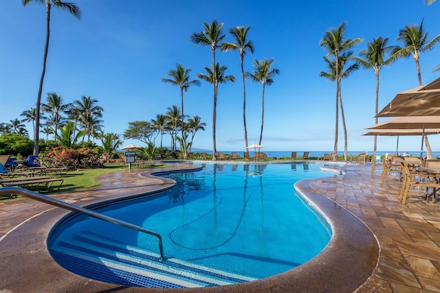 pool featuring a water view and a patio
