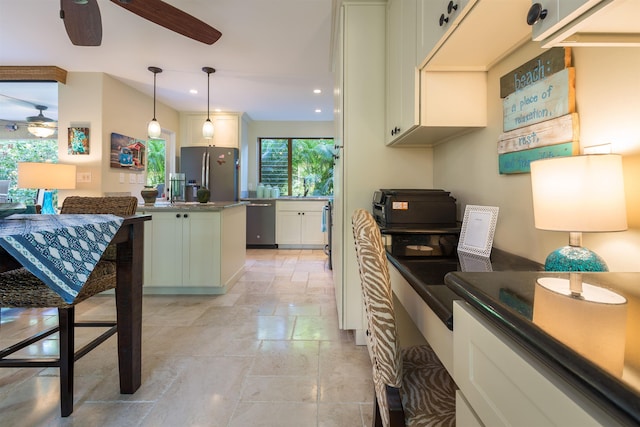 kitchen featuring stone tile floors, dark countertops, appliances with stainless steel finishes, pendant lighting, and recessed lighting
