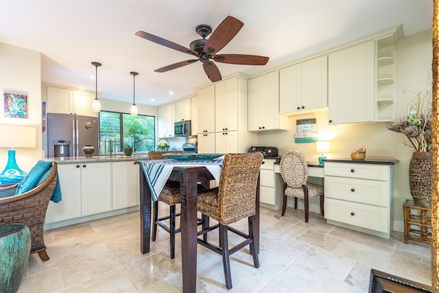 kitchen with pendant lighting, open shelves, appliances with stainless steel finishes, a ceiling fan, and built in study area