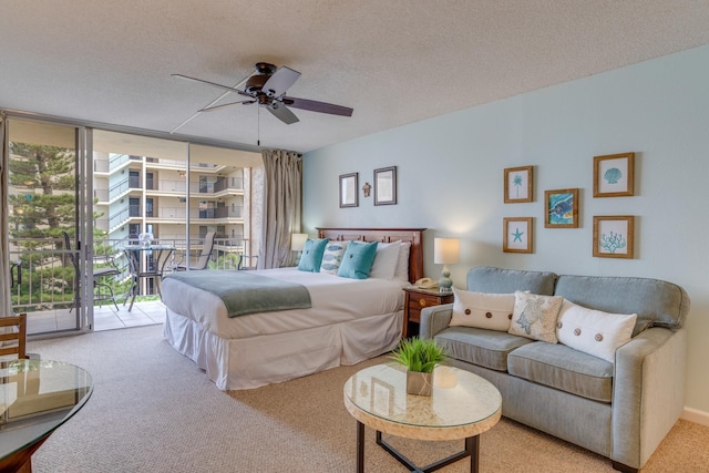 carpeted bedroom with a textured ceiling, ceiling fan, floor to ceiling windows, and access to outside